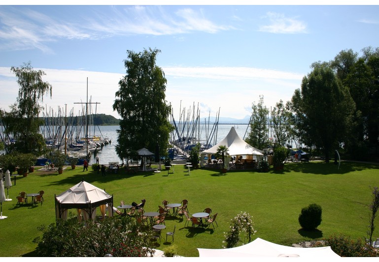 Yachthotel Chiemsee - Blick vom Seeseitenzimmer auf die Hotelwiese und Chiemsee